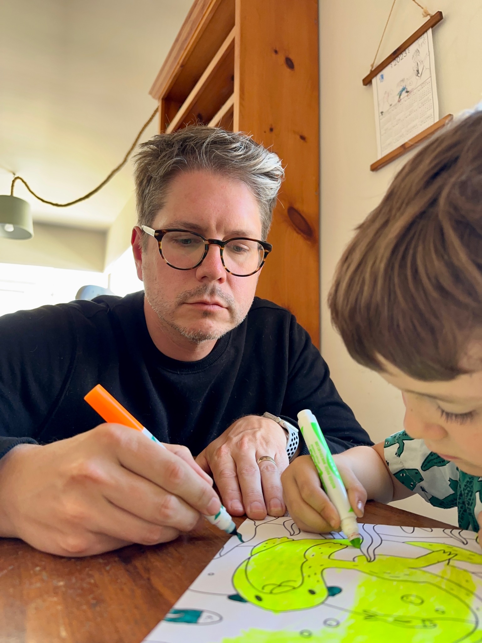 David drawing with his son at a table